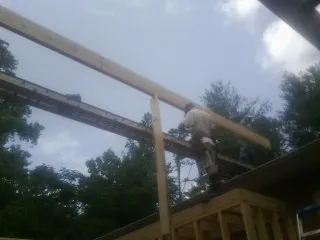 Carpenter setting a ridge beam over a new addition frame — Ice Dam Removal by Roofing Brothers in Morris Plains