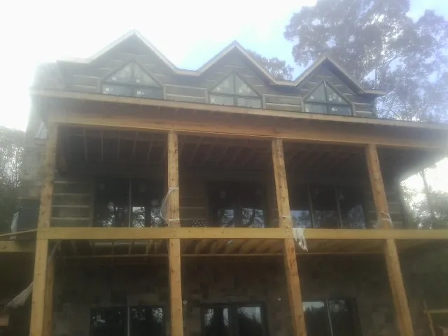 Dormers and porch framing on a large log home under construction — Roof Coating work by our crew in Morris Plains