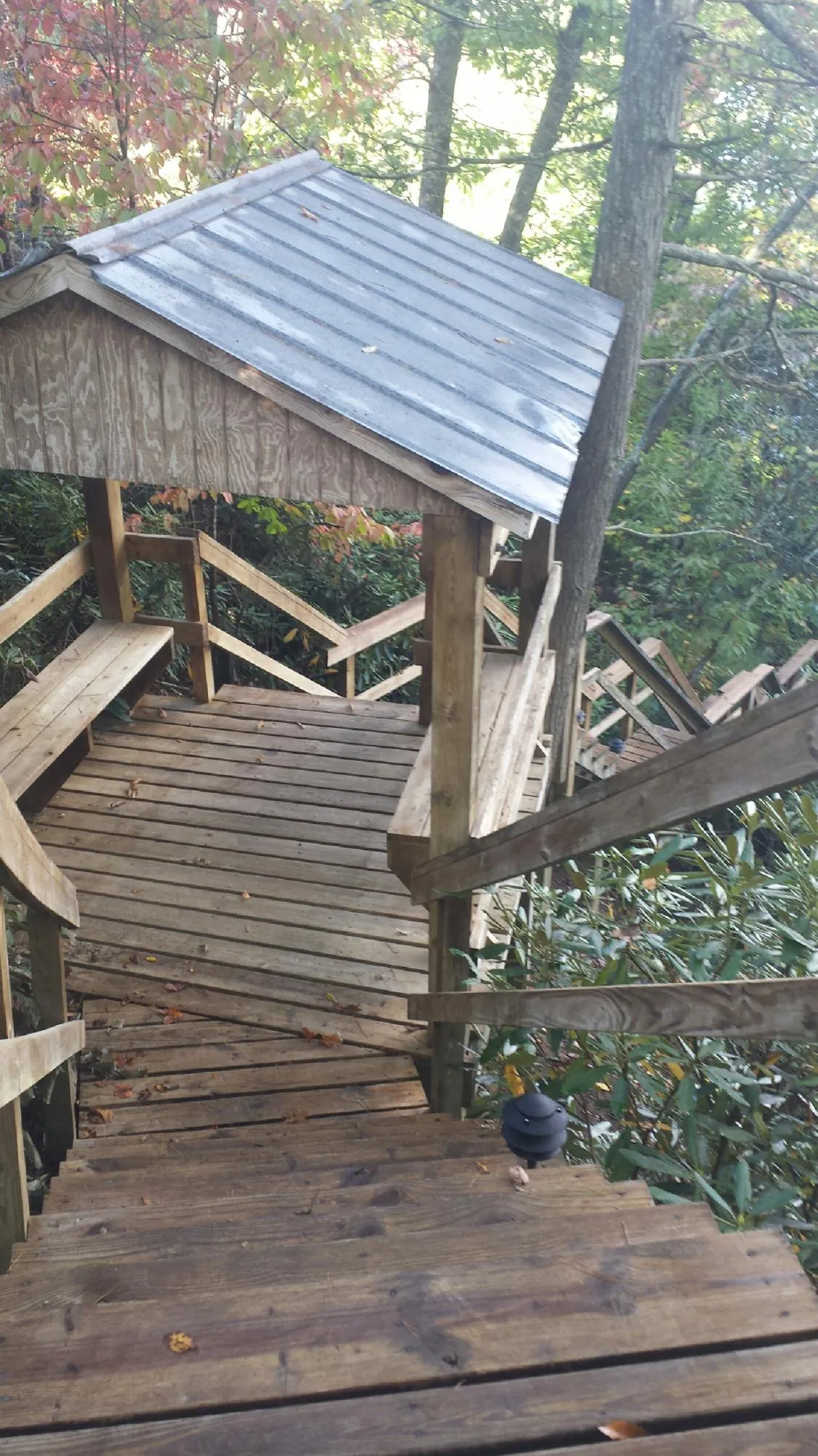 Metal roofed shelter over wooden steps on a wooded walkway — Skylight Repair & Installation work by our crew in Morris Plains