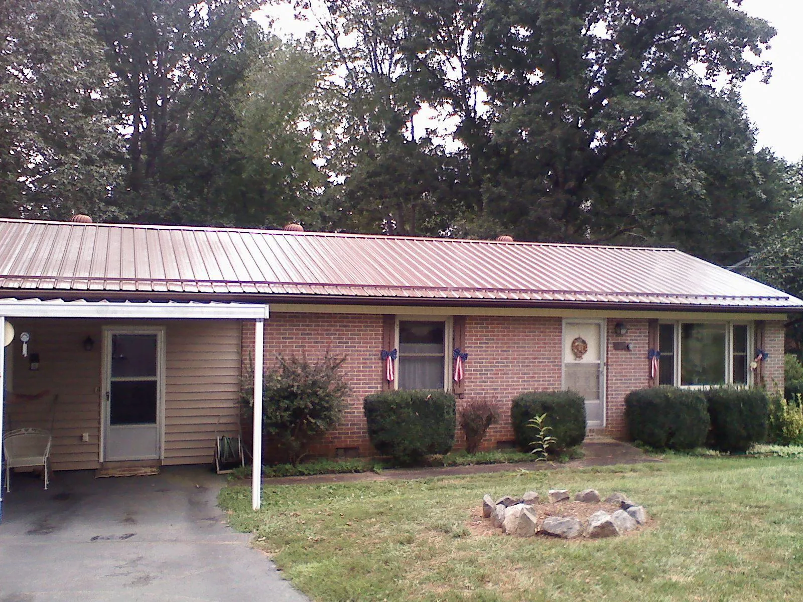 Bronze metal roof and carport on a brick ranch home — Roof Repair work by our crew in Morris Plains